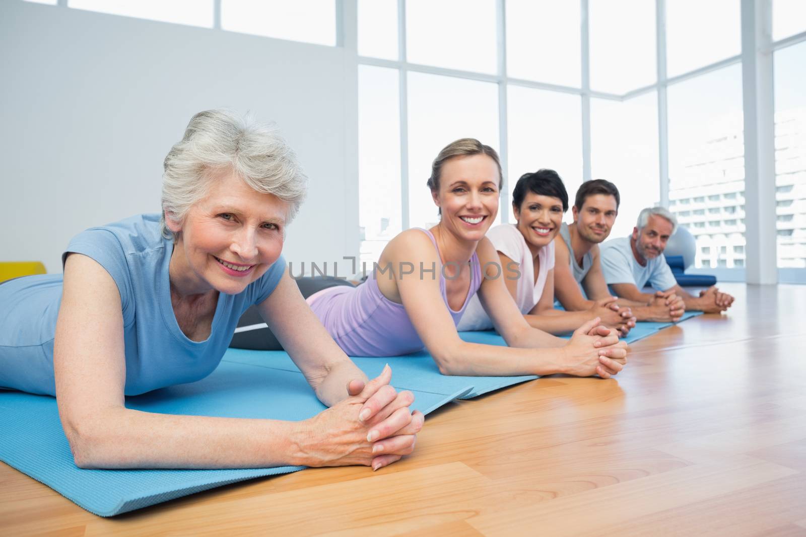 Fitness group lying in row at yoga class by Wavebreakmedia