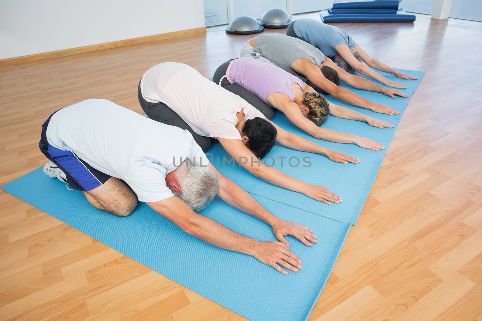 Fitness group bowing in row by Wavebreakmedia