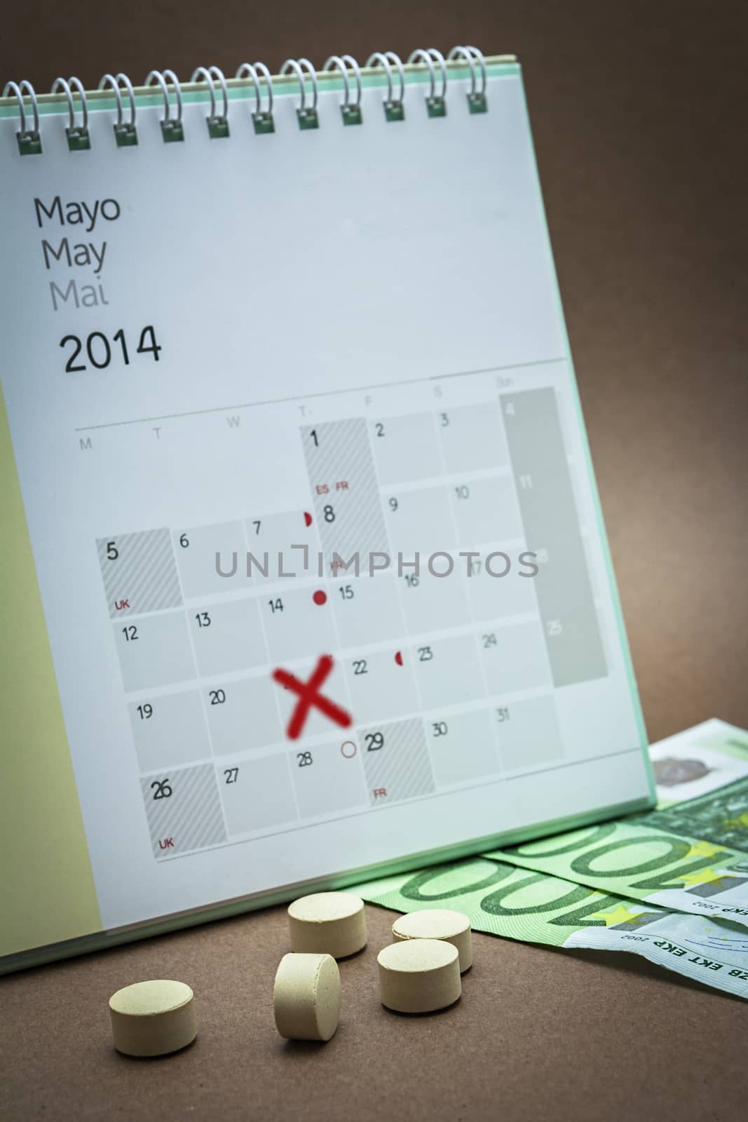 control pills on a  may calendar, concept of pharmaceutical copayment