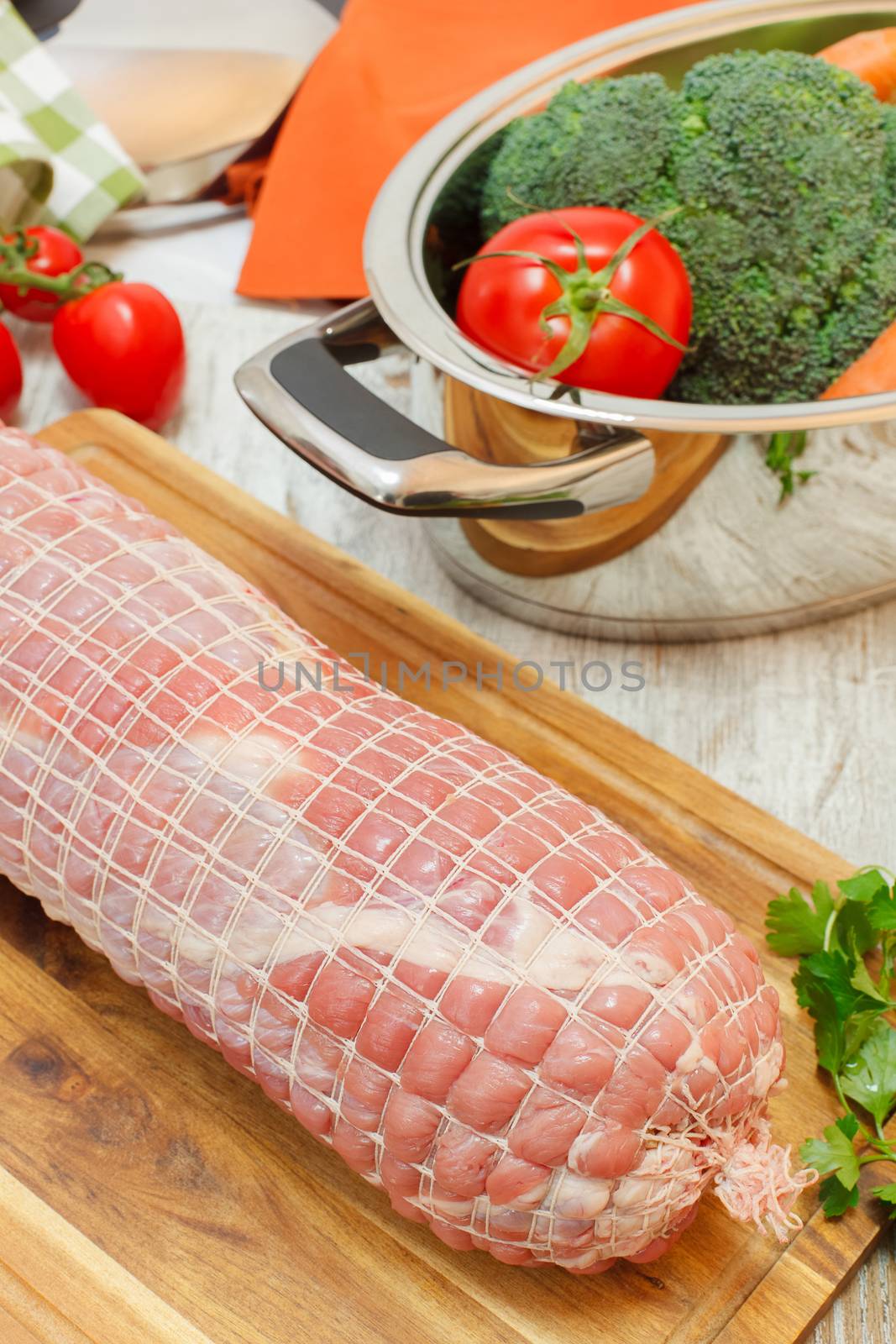 Stuffed Veal Roulade on wooden cutting board. Uncooked meat. Raw fresh veal roulade ready to cooking