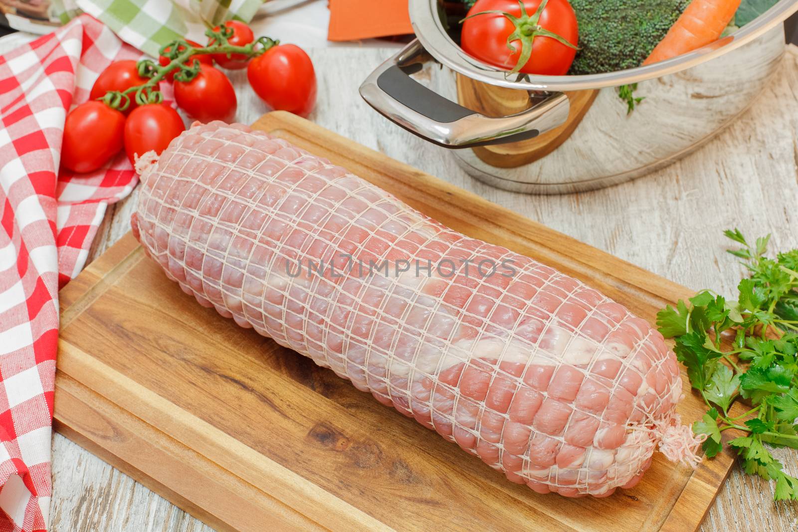 Stuffed Veal Roulade on wooden cutting board. Uncooked meat. Raw fresh veal roulade ready to cooking