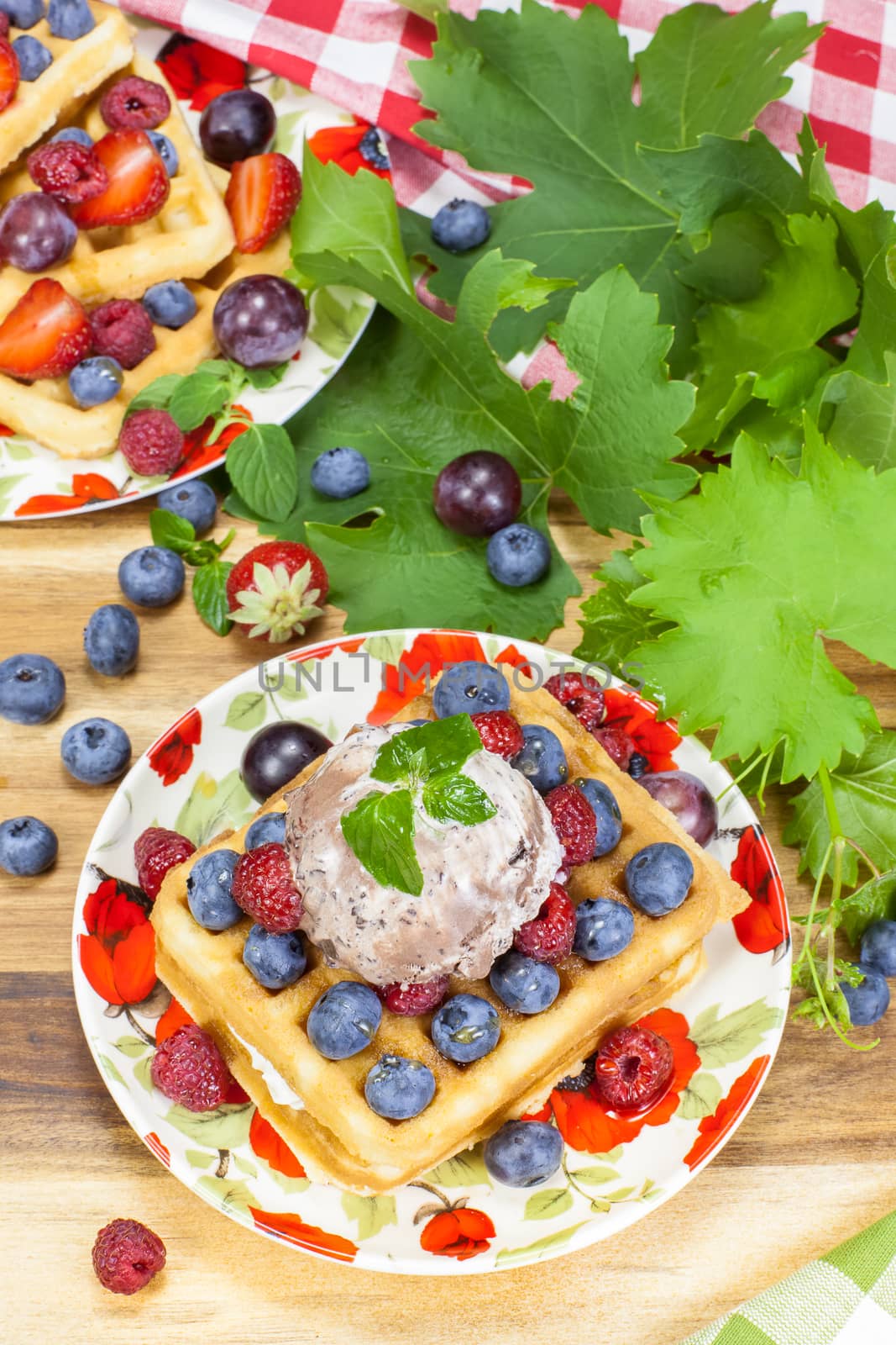 Belgian waffles with fresh raspberries, grapes and blueberries .