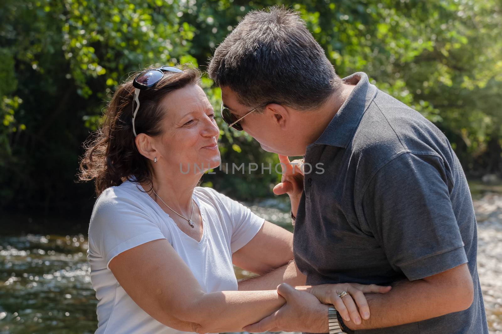 Happy middle aged couple near the river. by Slast20