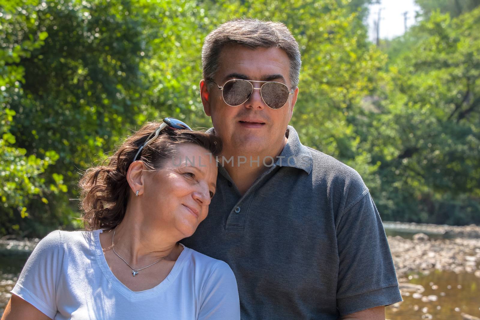 Middle-aged couple outdoors. Happy middle aged couple near the river. Summer holiday. Happy family concept.