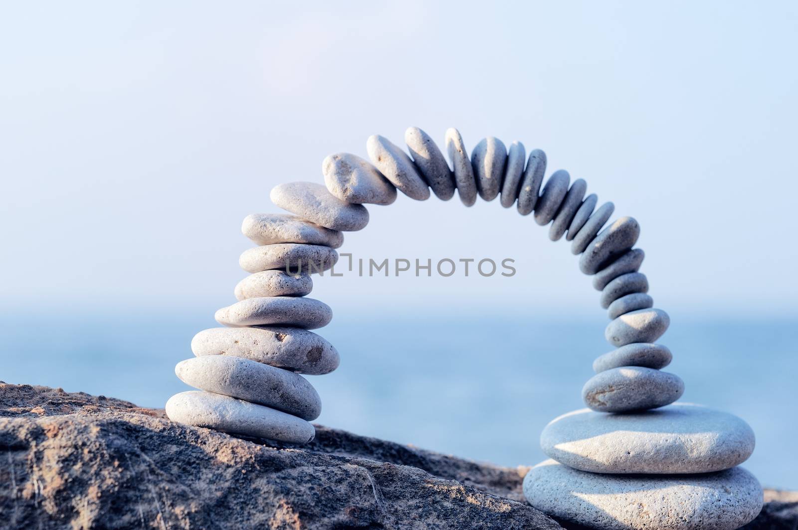 Arch of white pebbles in the balance on the seacoast