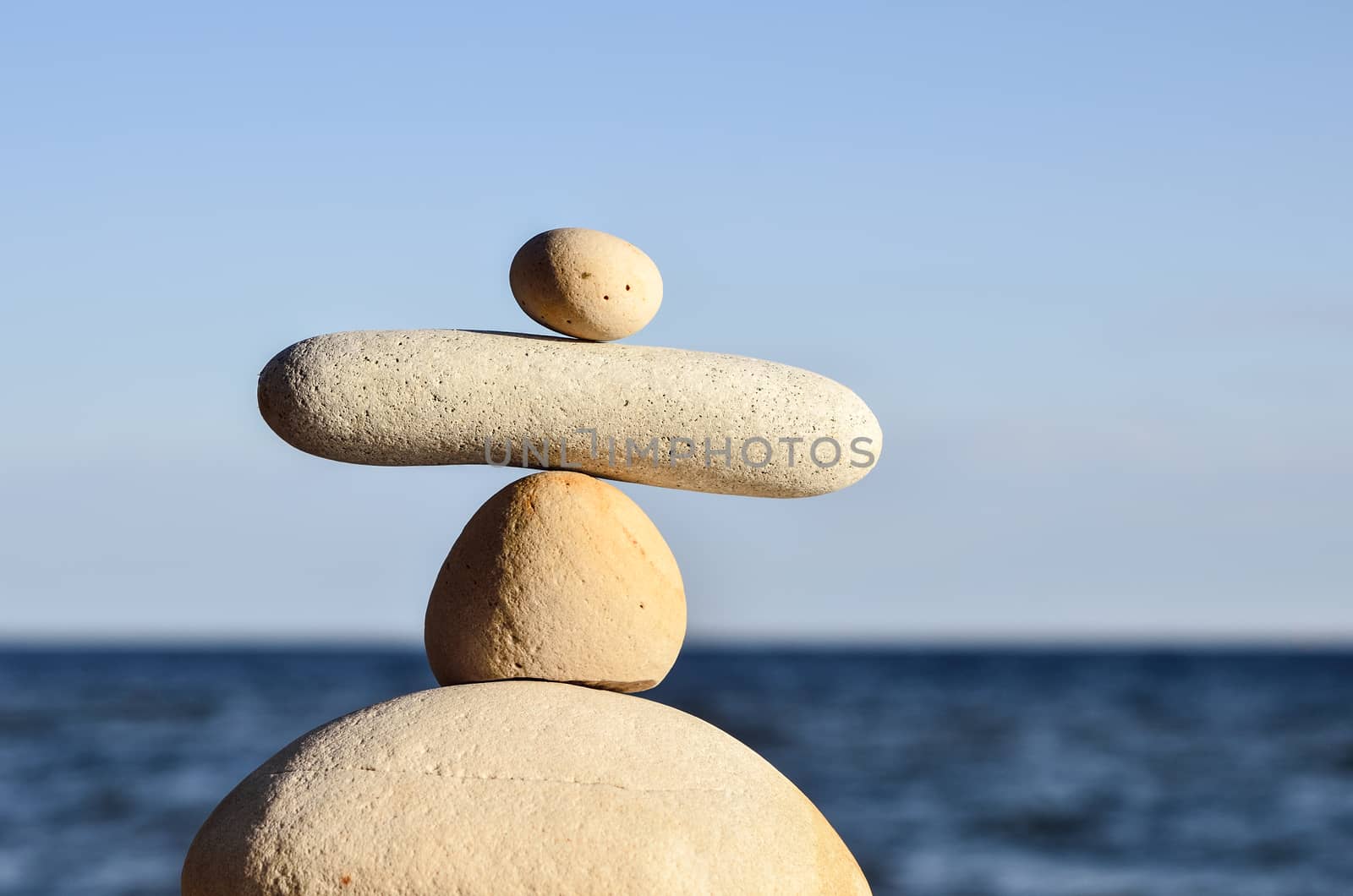 Balancing of white pebbles each other on the seacoast