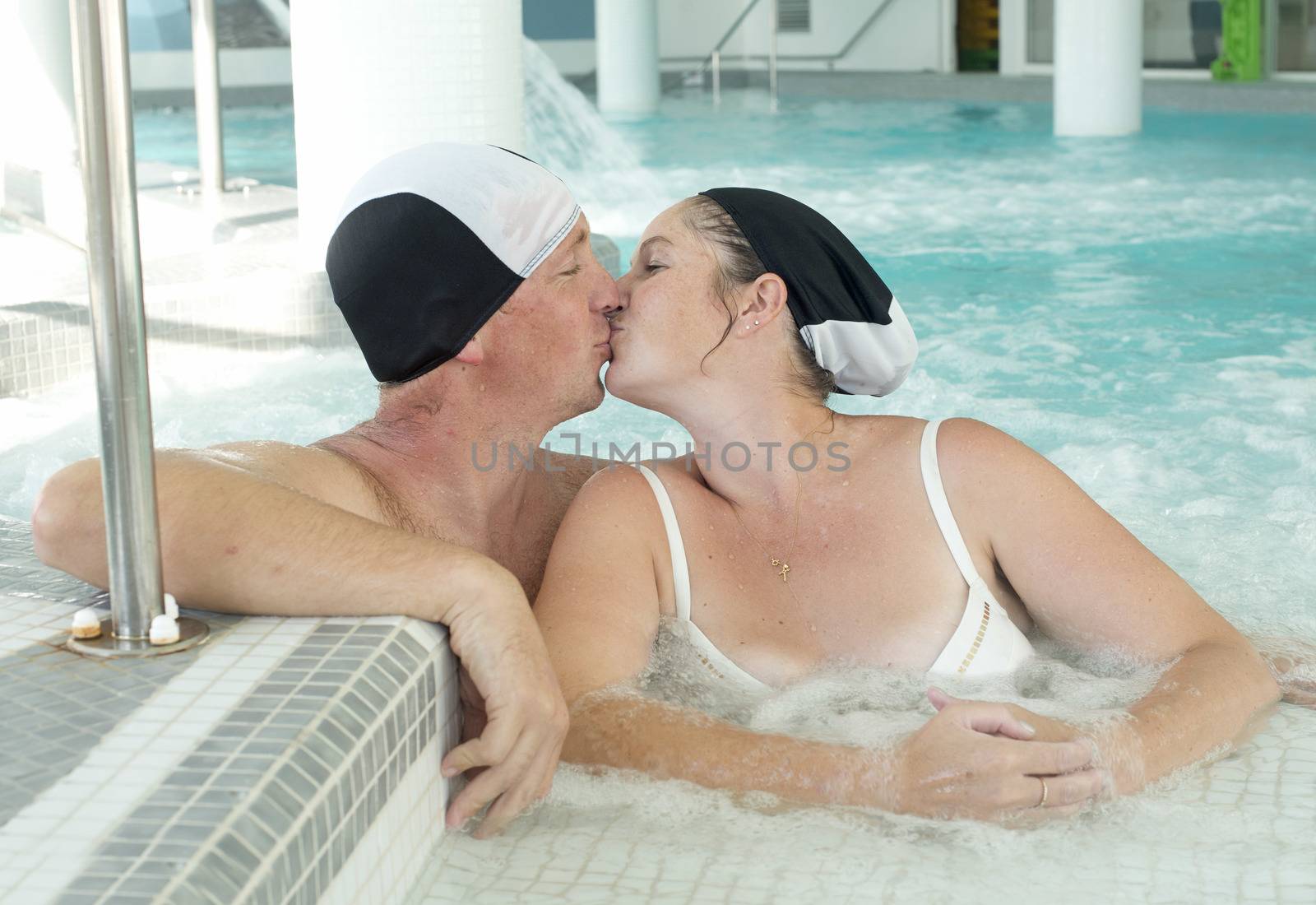 two lovers kissing in a swimming pool