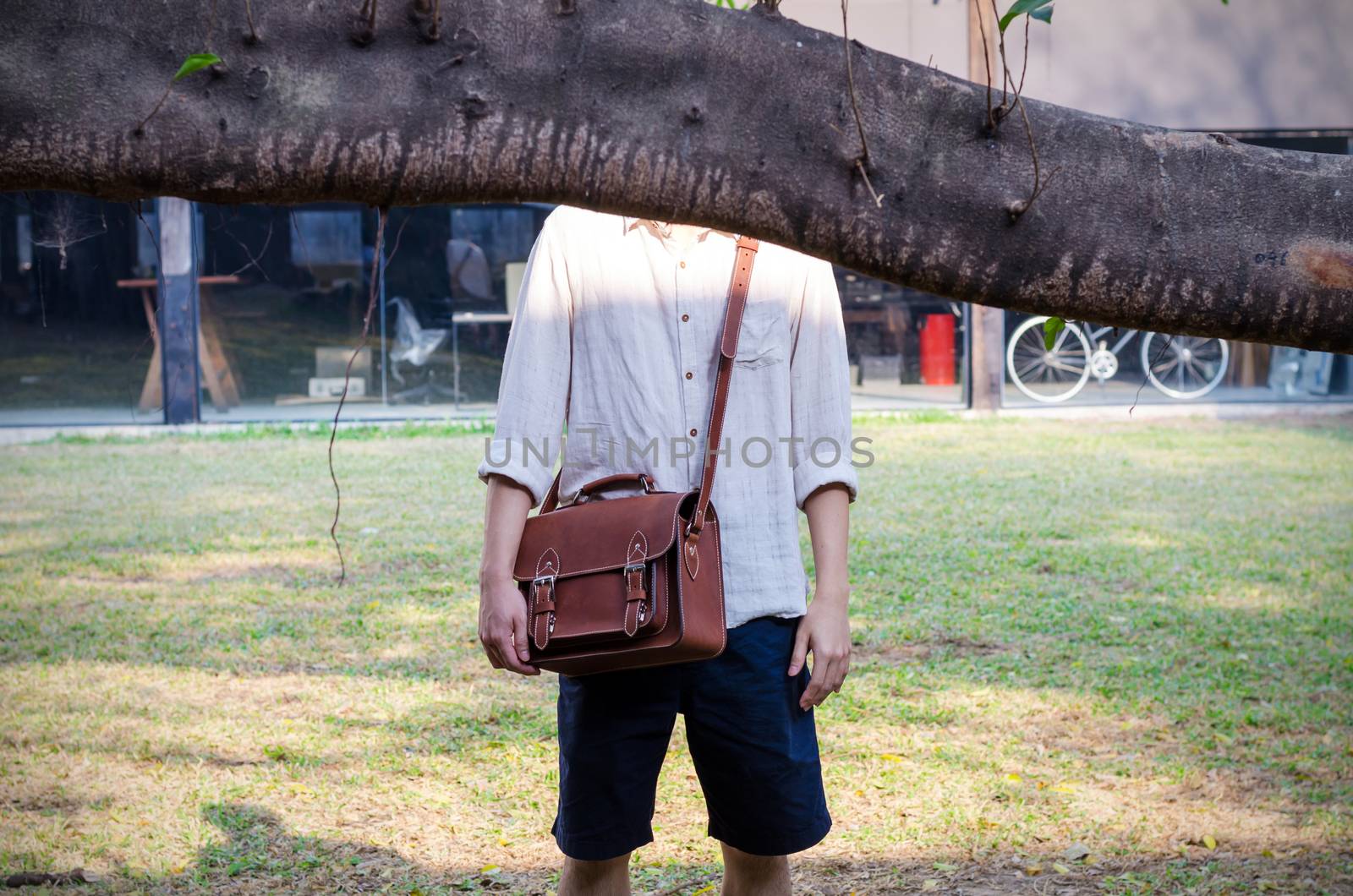 Fashionable man with leather bag, Nature location