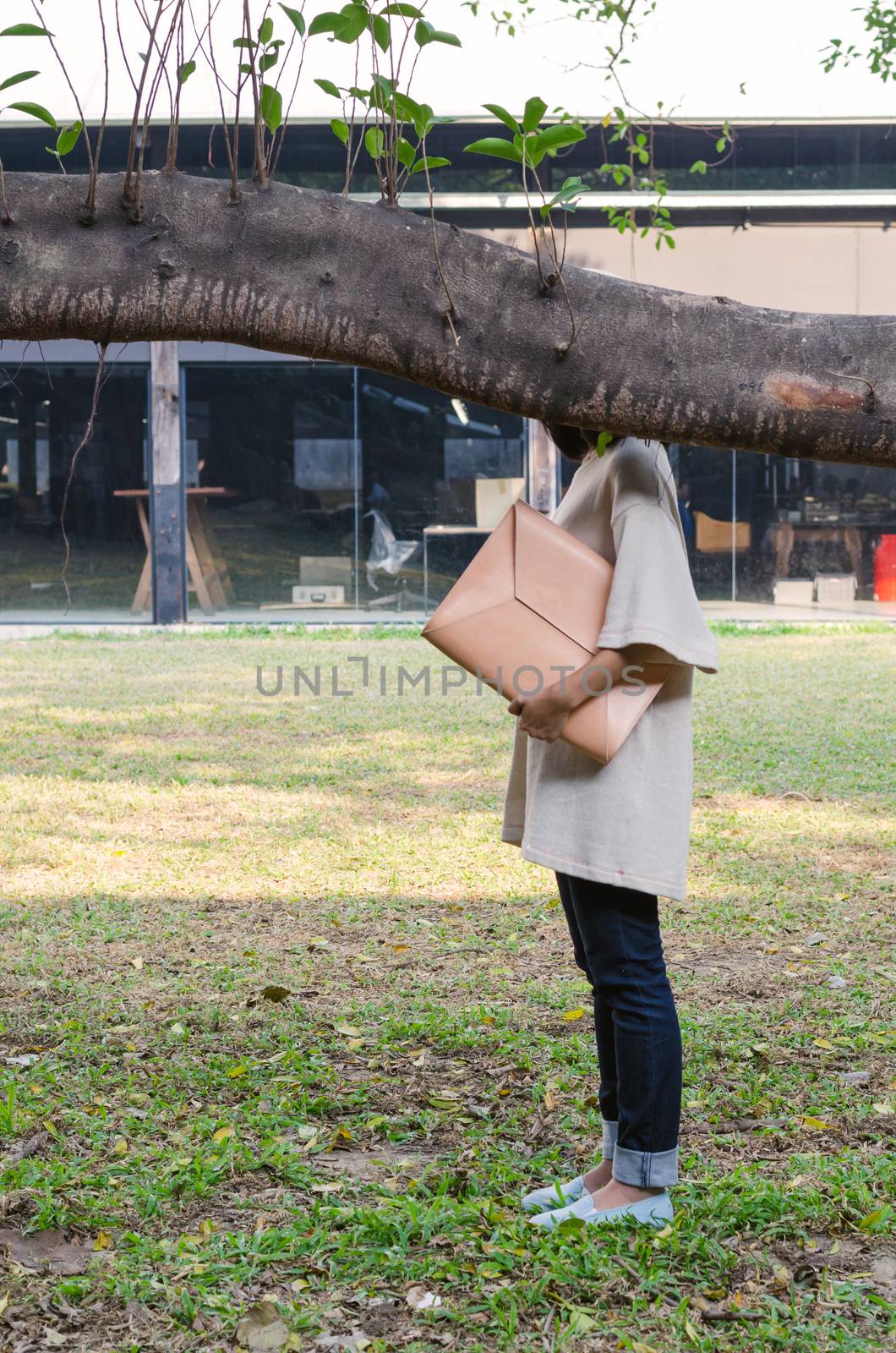 Woman with vintage leather bag on nature background by siraanamwong