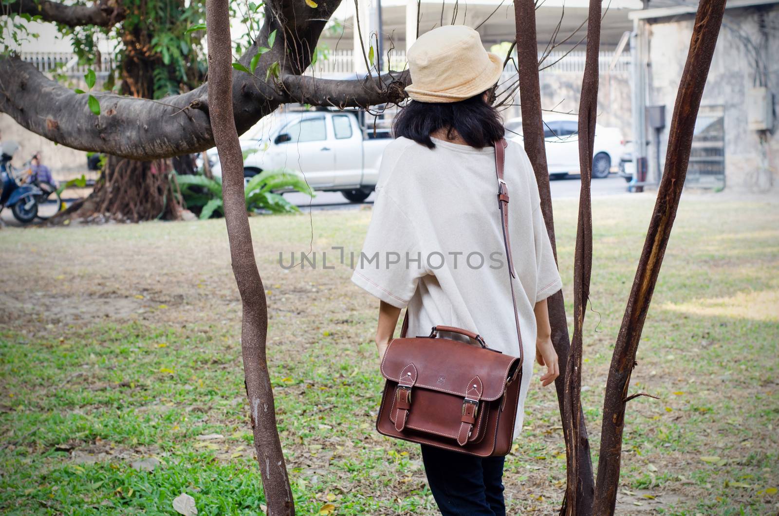 Fashion woman with vintage leather bag, nature background
