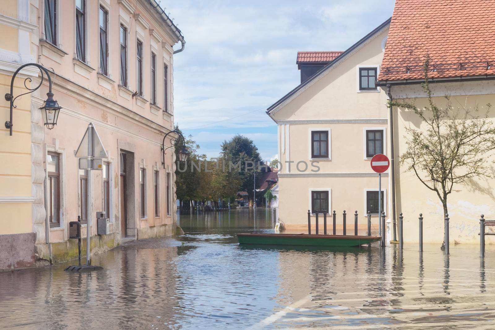 Rural village houses in floodwater. Road with the river overflown with the residents in their homes. Floods and flooding the streets. Natural disaster.  