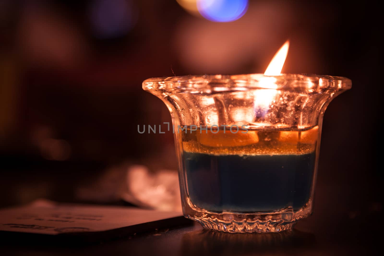 burning candle on the wooden table in the club