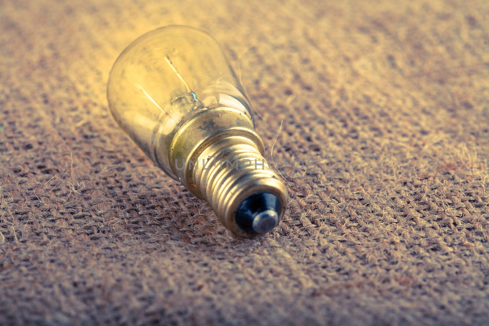 traditional retro  light bulb glowing on textured background artistic toned photo