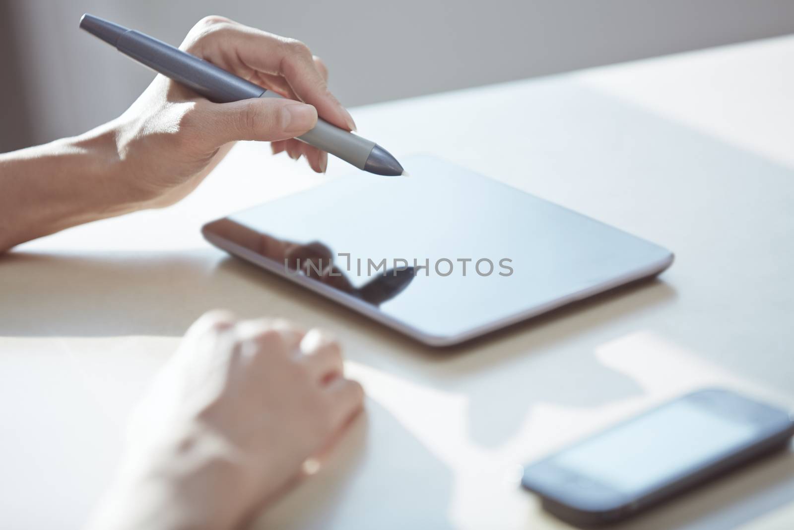 Hands of designer working with tablet PC and stylus