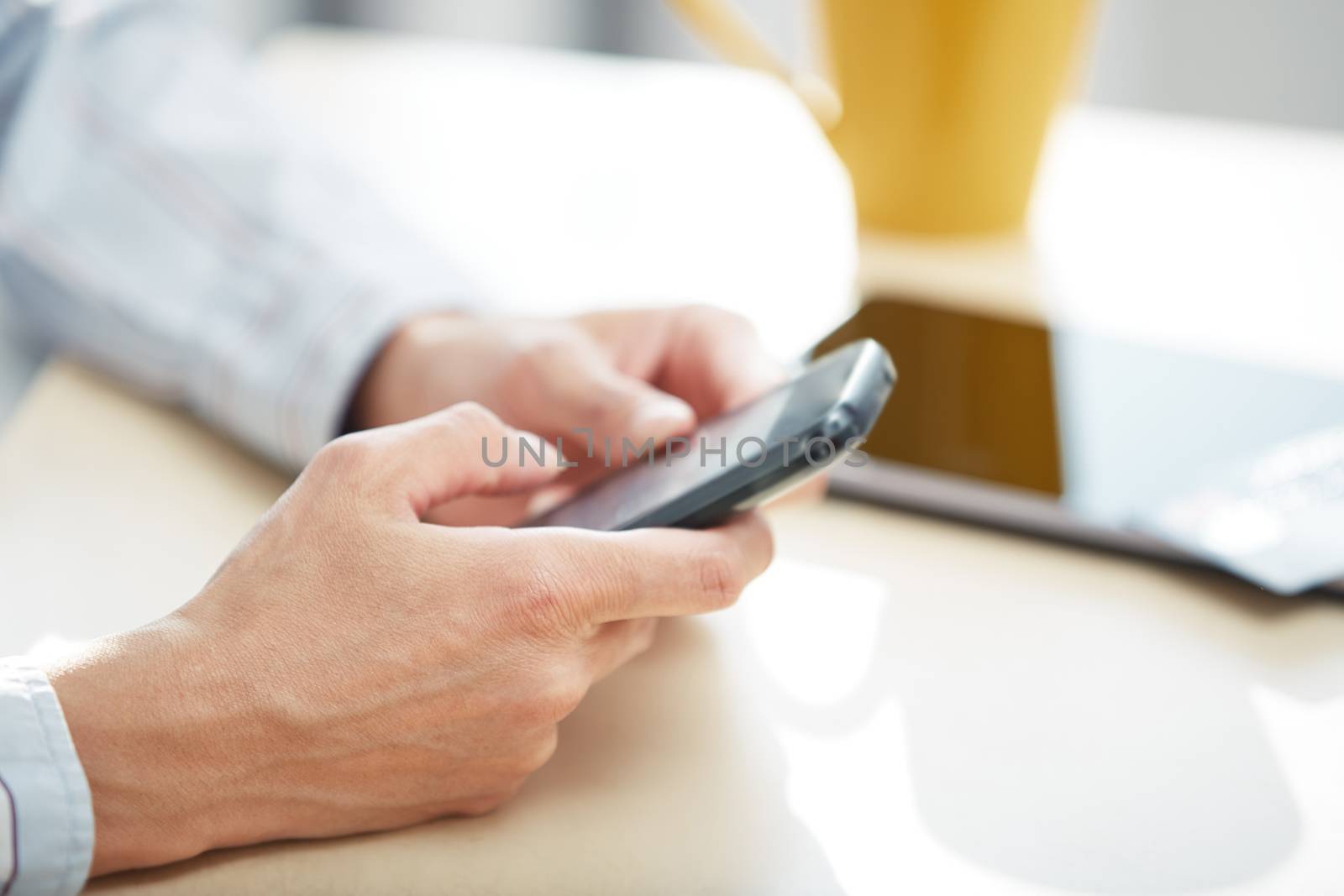 Hands of woman sending SMS via smartphone at lunch