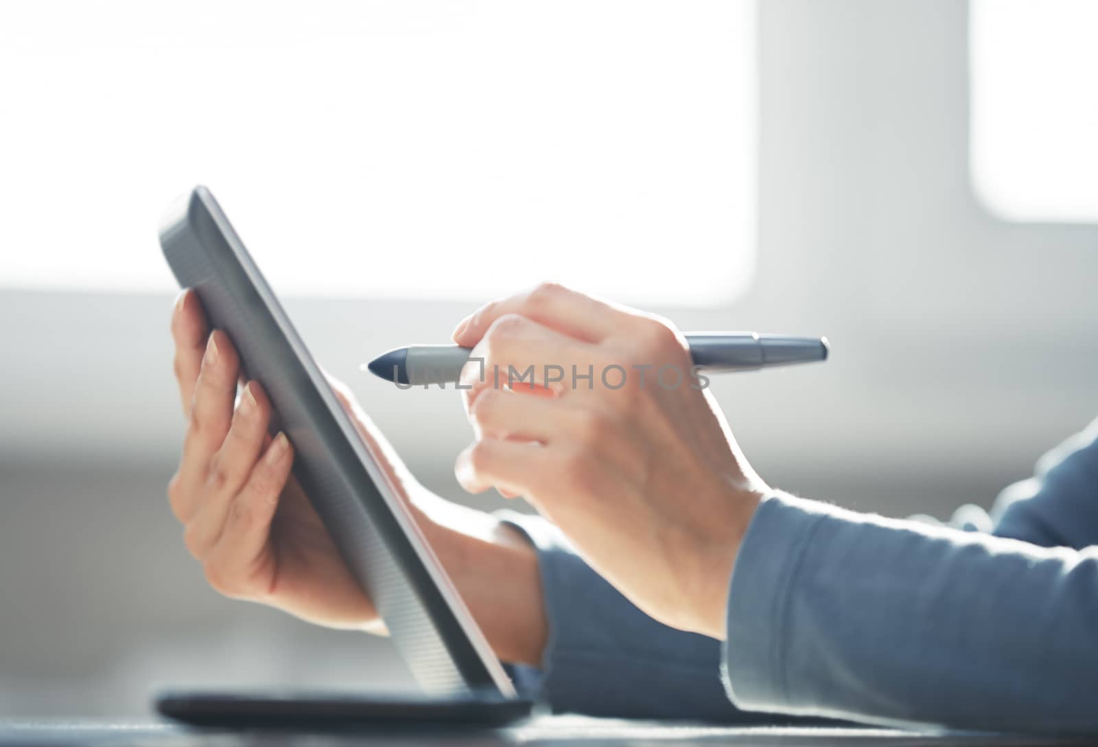 Hands of woman working with digital tablet
