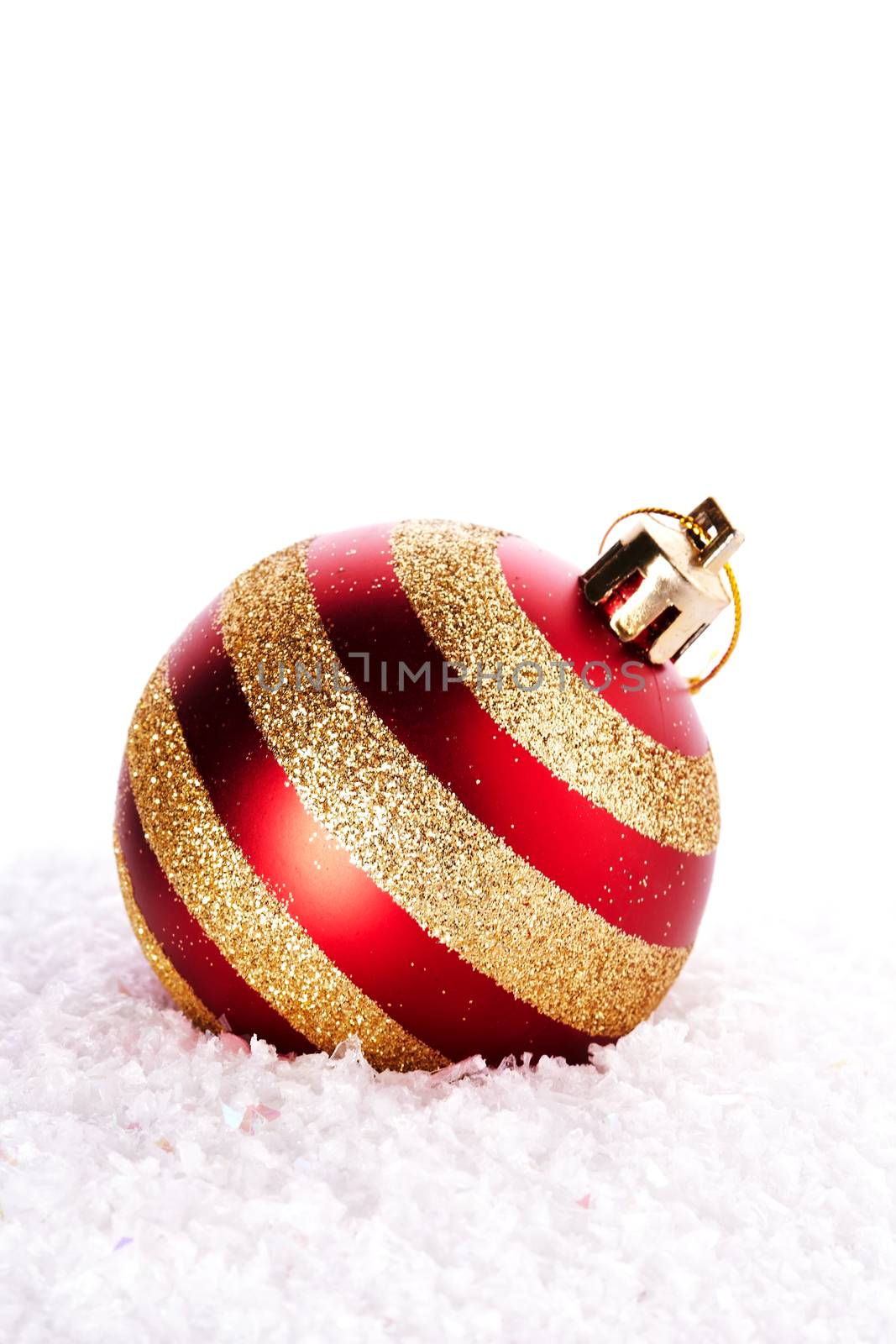 New Year's striped ball on snow. New Year's red ball. Christmas ball. Christmas tree decorations. Christmas jewelry.