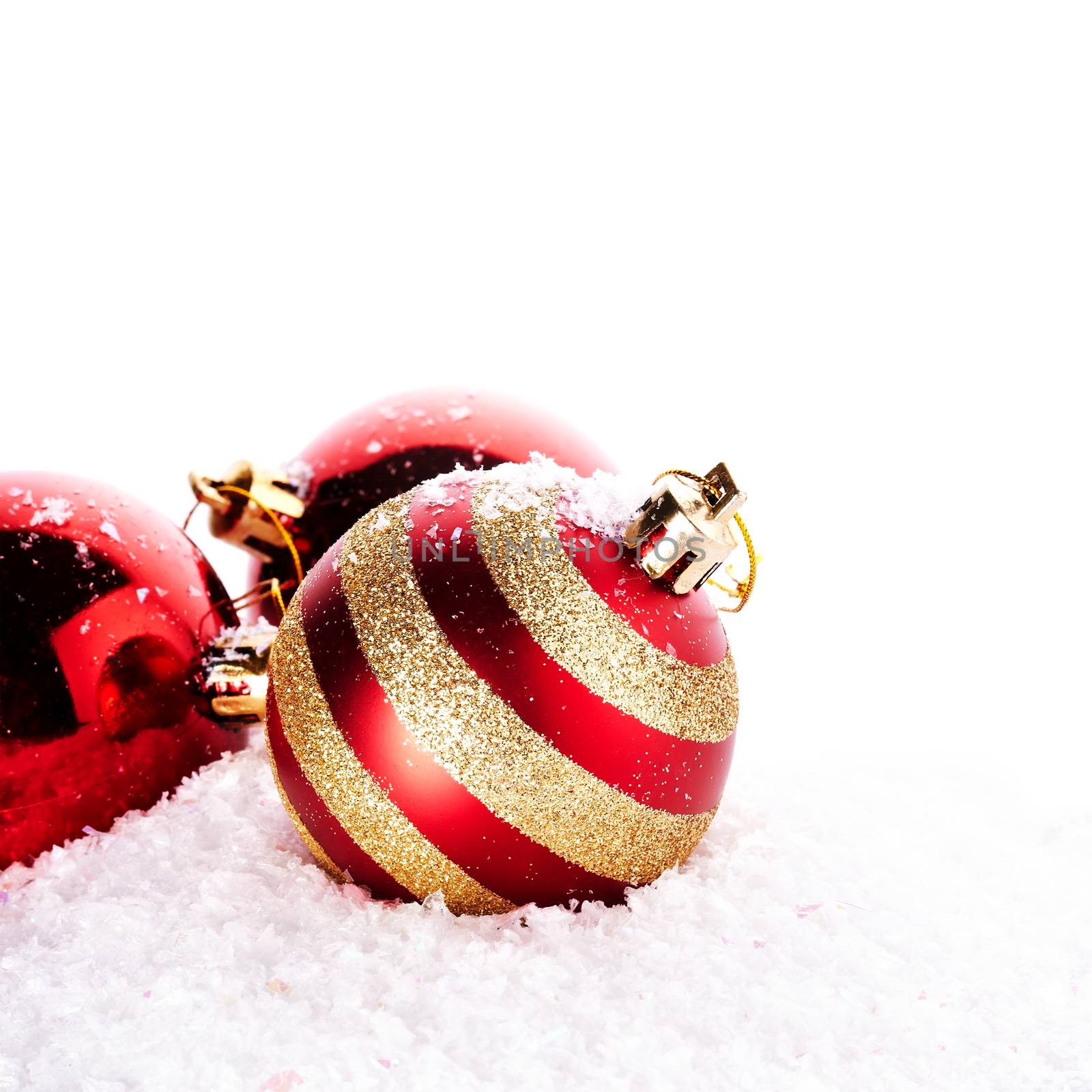 New Year's striped balls on snow. New Year's red balls. Christmas balls. Christmas tree decorations. Christmas jewelry.