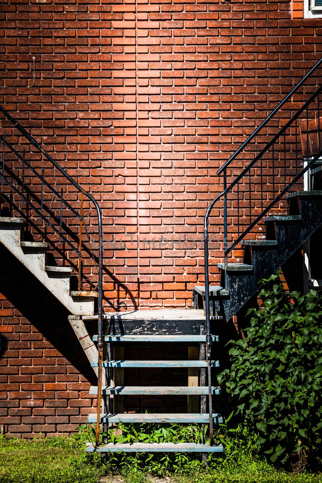 Symmetrical Staircases merging together and brick wall