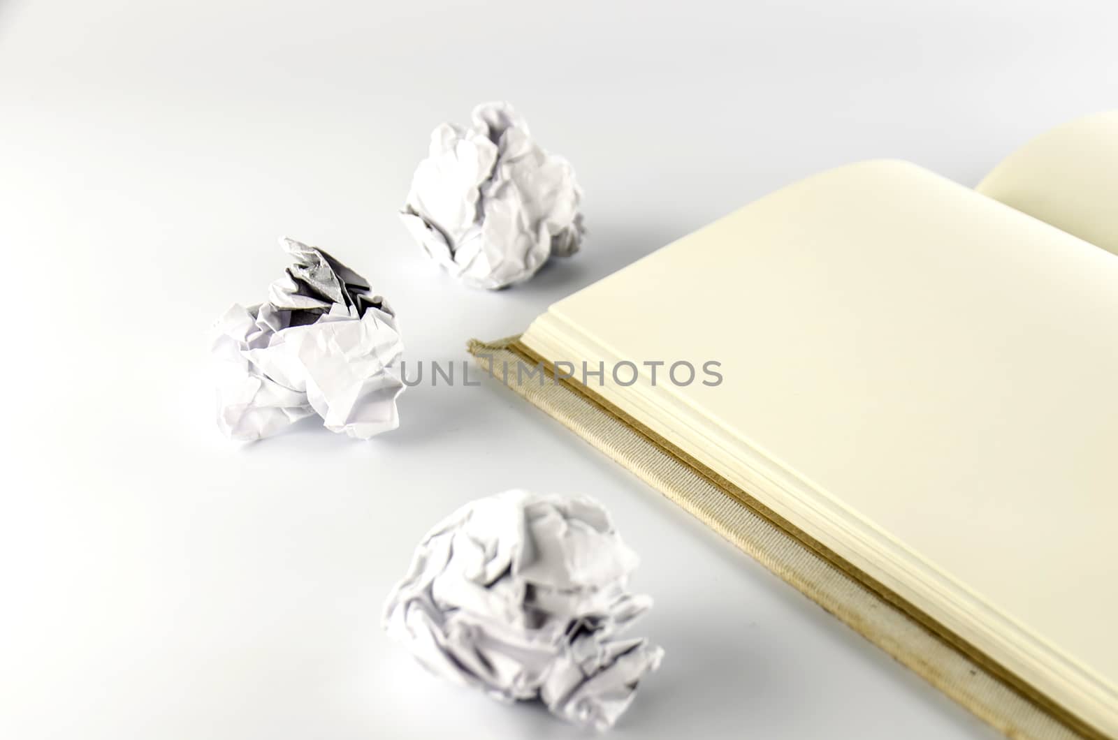 crumpled paper and notebook on a white background