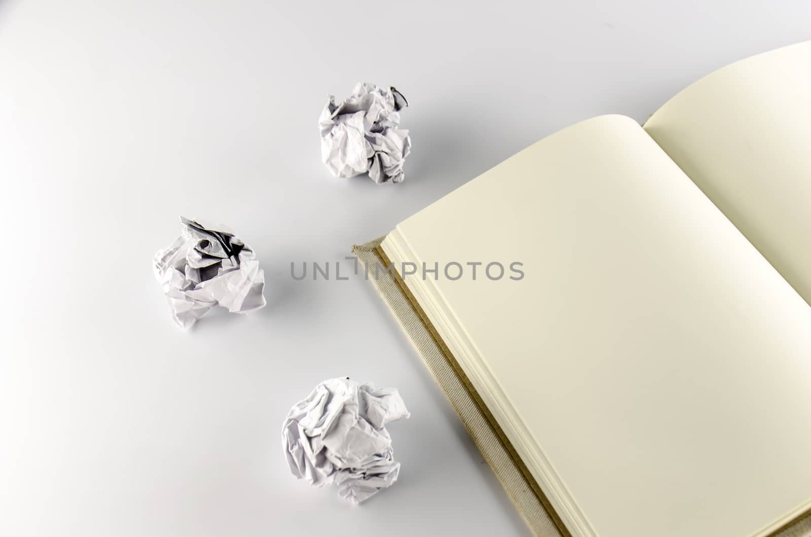 crumpled paper and notebook on a white background