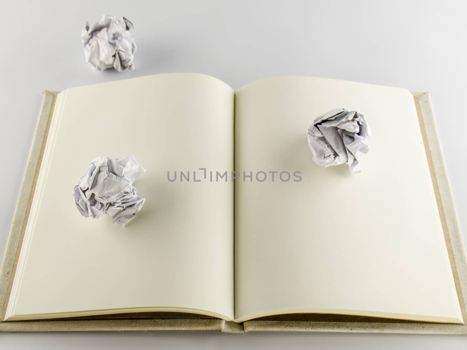 crumpled paper and notebook on a white background