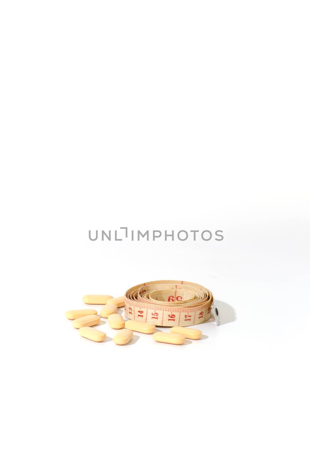 pills and measuring tape on a white background