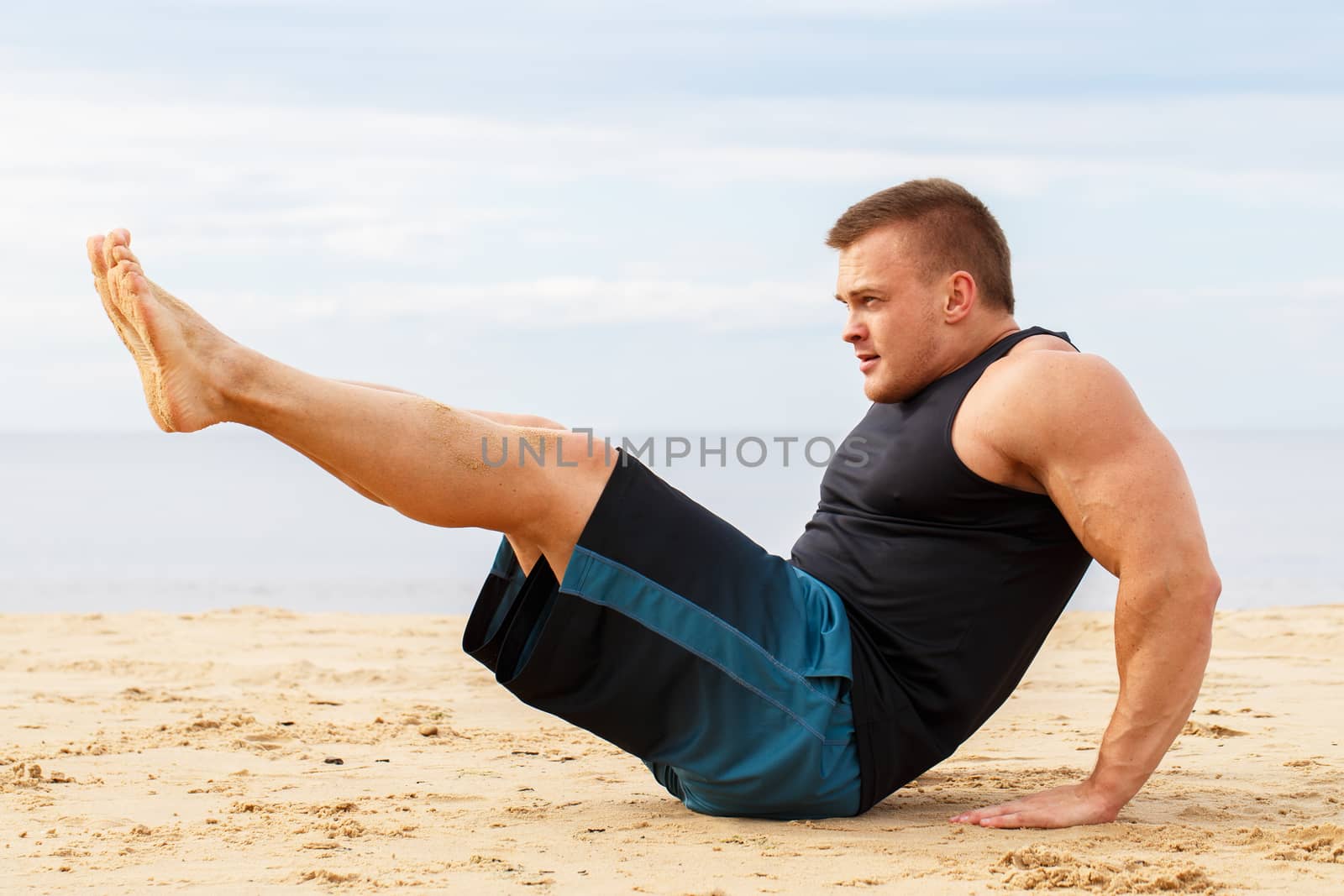 Sport, fitness. Bodybuilder during workout on the beach