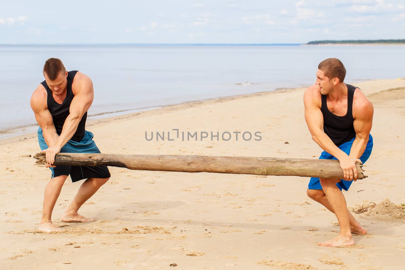 Sport, fitness. Bodybuilders during workout on the beach