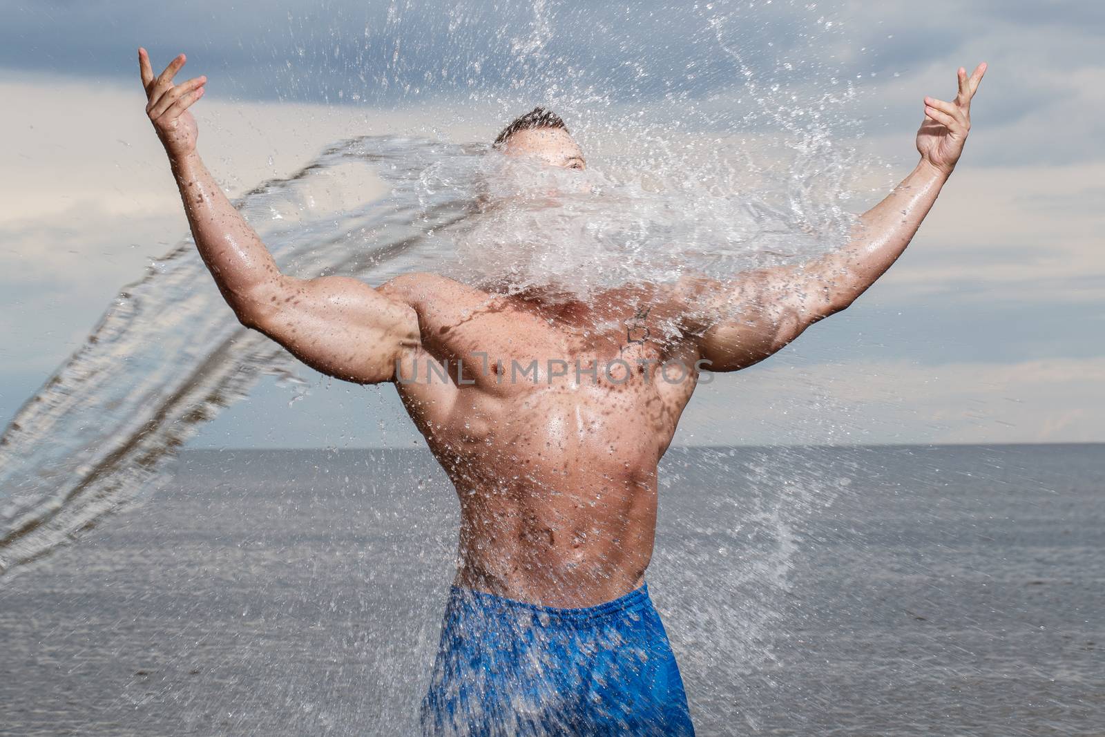 Sport, fitness. Bodybuilder with sexy body on the beach