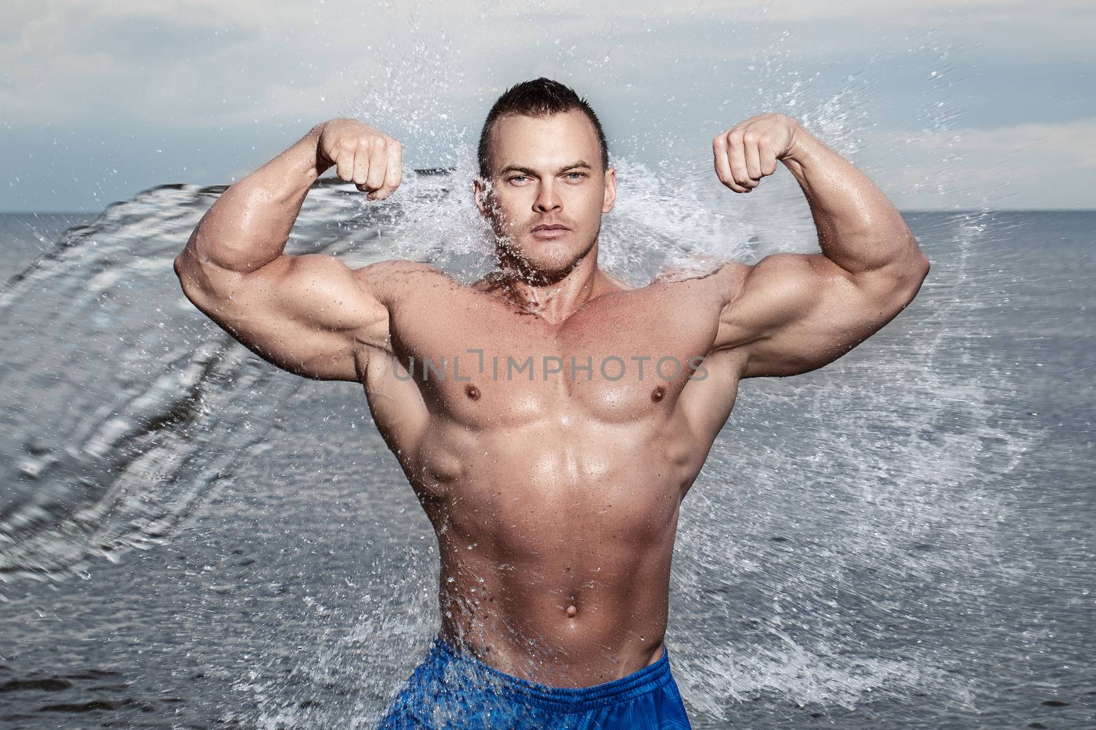 Sport, fitness. Bodybuilder with sexy body on the beach