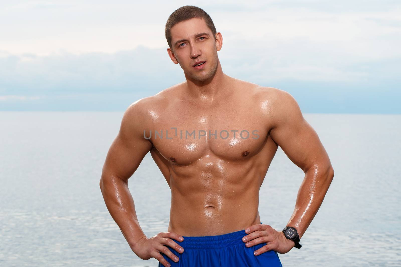 Sport, fitness. Bodybuilder with sexy body on the beach