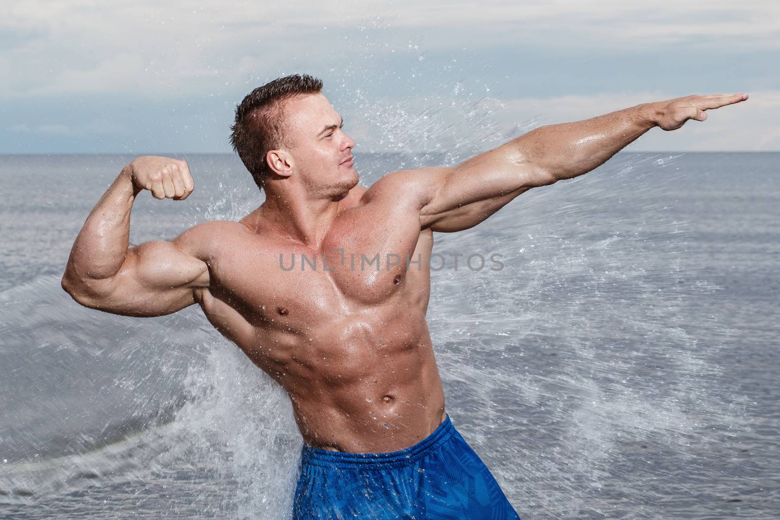 Sport, fitness. Bodybuilder with sexy body on the beach