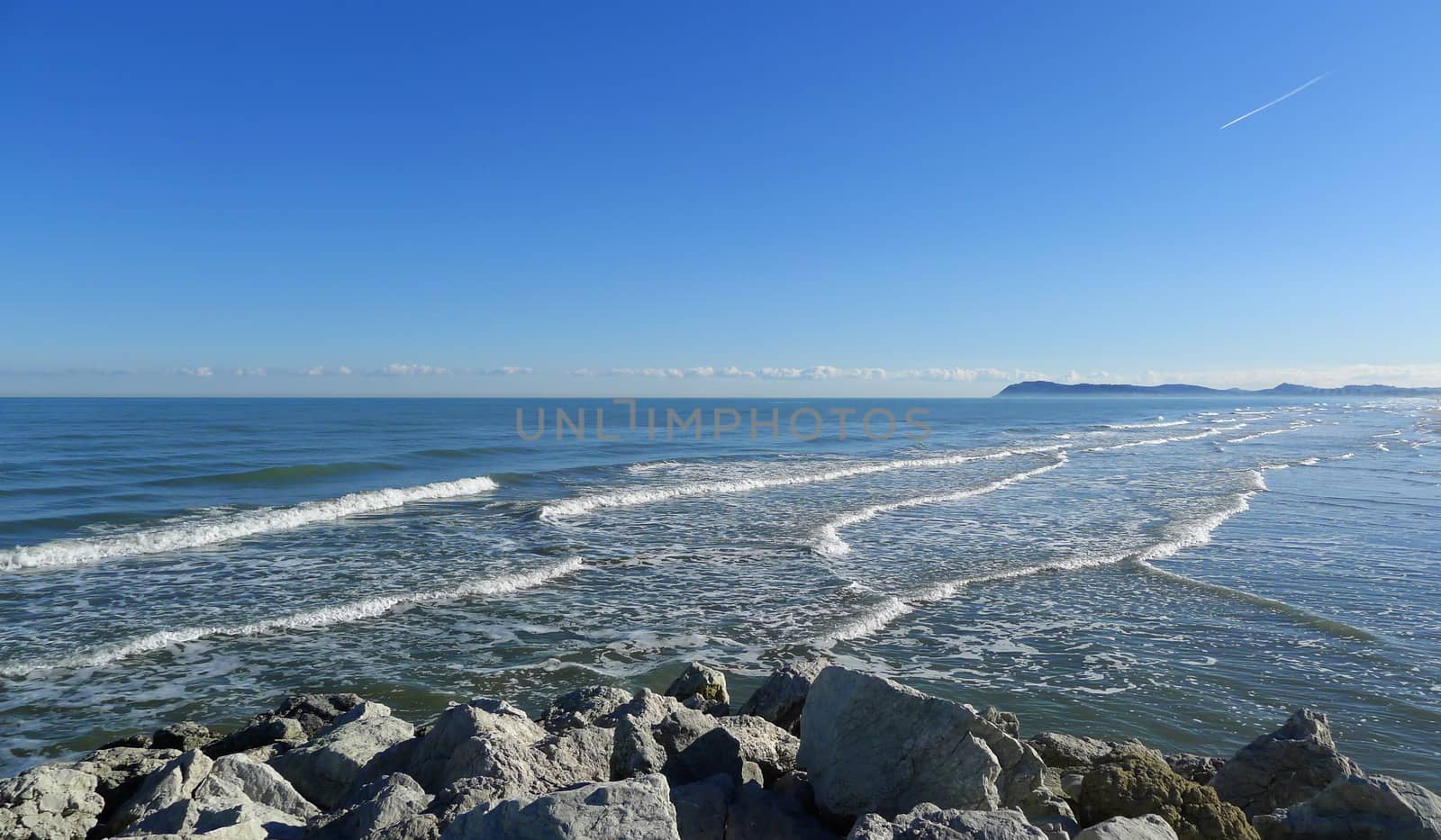 Relaxing and beautiful view of Adriatic seaside from Rimini in a sunny day with blue sky and clean sea with waves, Italy, Europe.