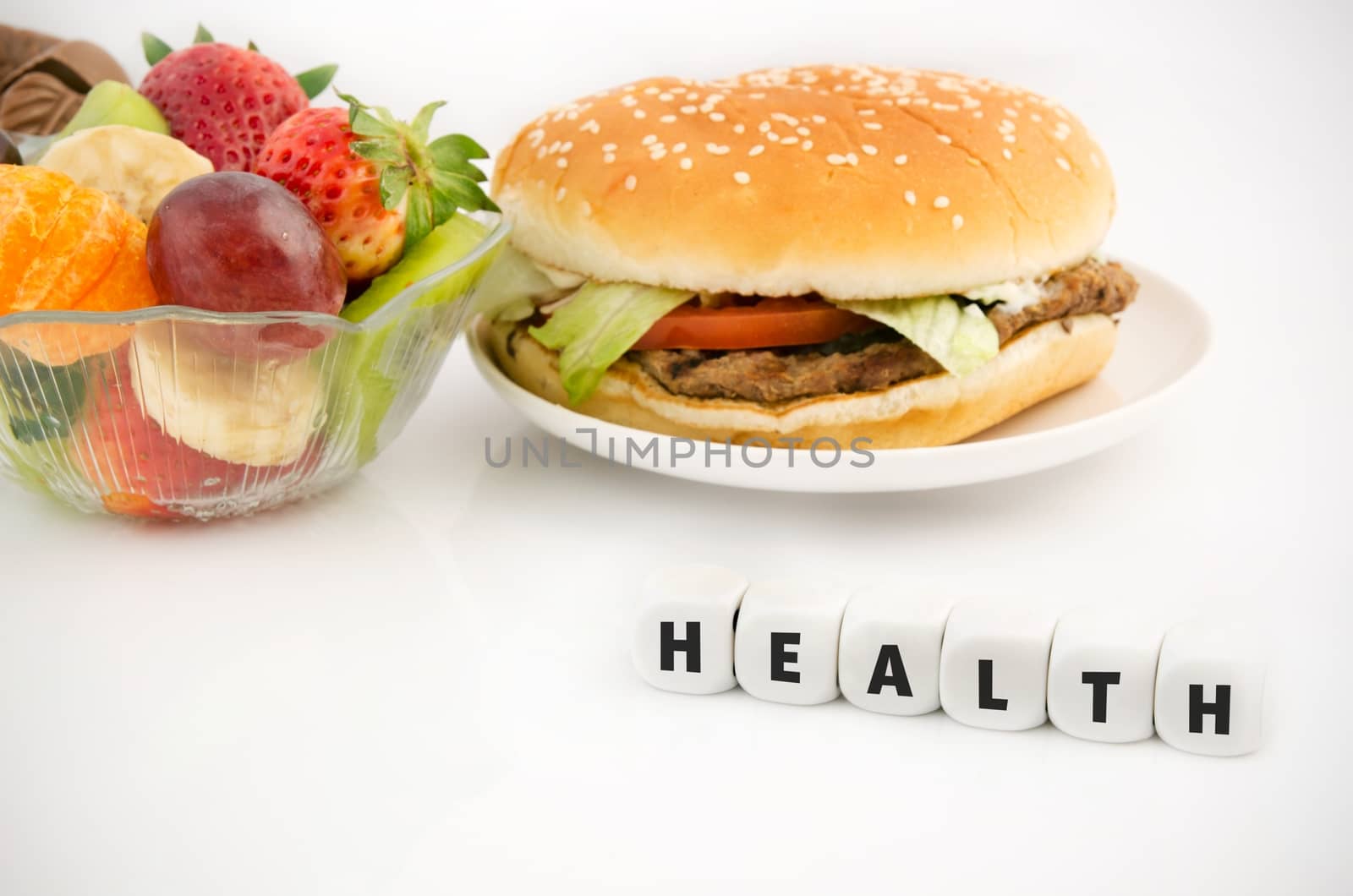 Health word on dices. Hamburger and fruits in babkground