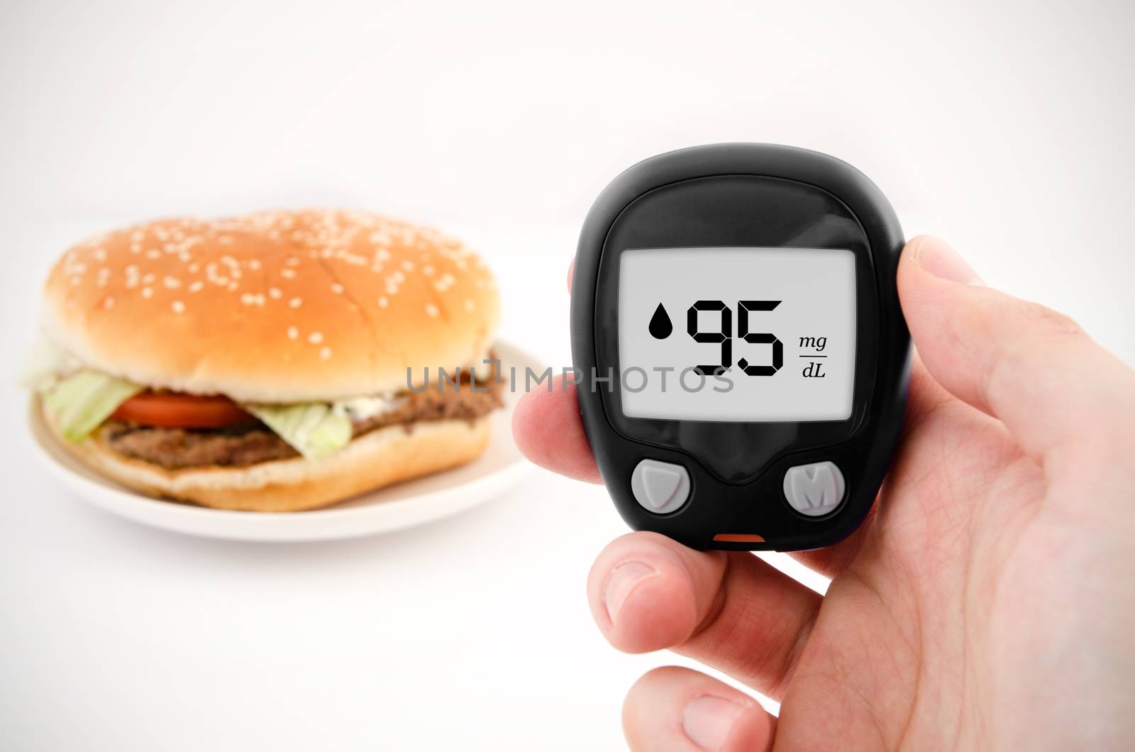 Hand holding meter. Diabetes doing glucose level test. Hamburger by simpson33