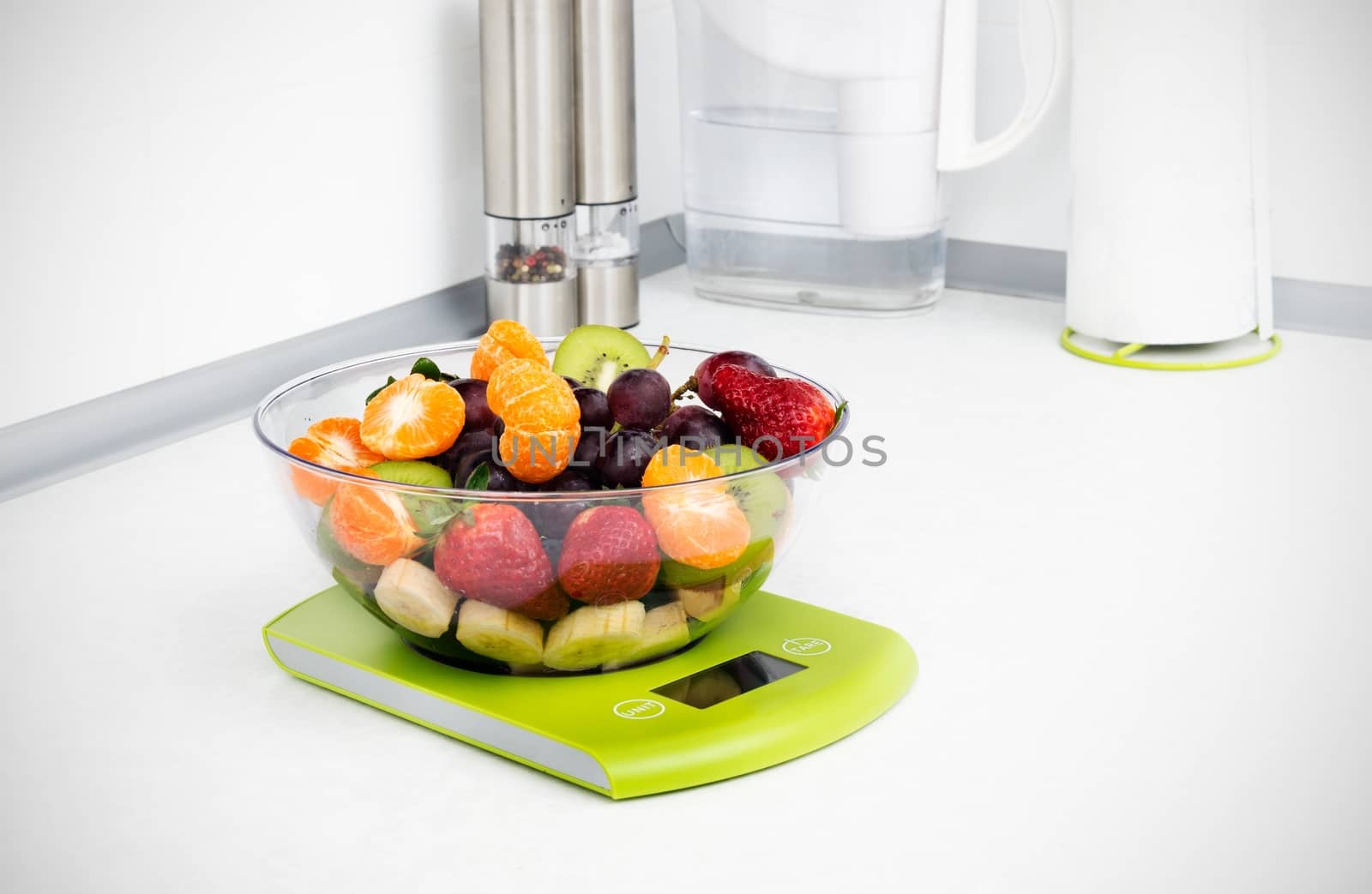 Lots of fruit on the kitchen scale in a modern kitchen