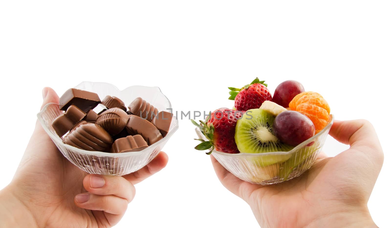 Choose healthy foods. Bowl with chocolates and a bowl of fruit by simpson33