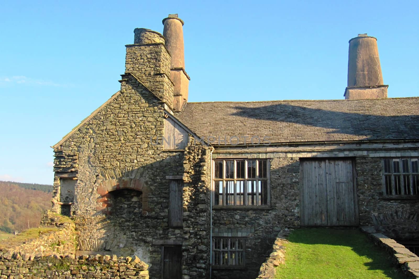 an old stone building with large chimneys