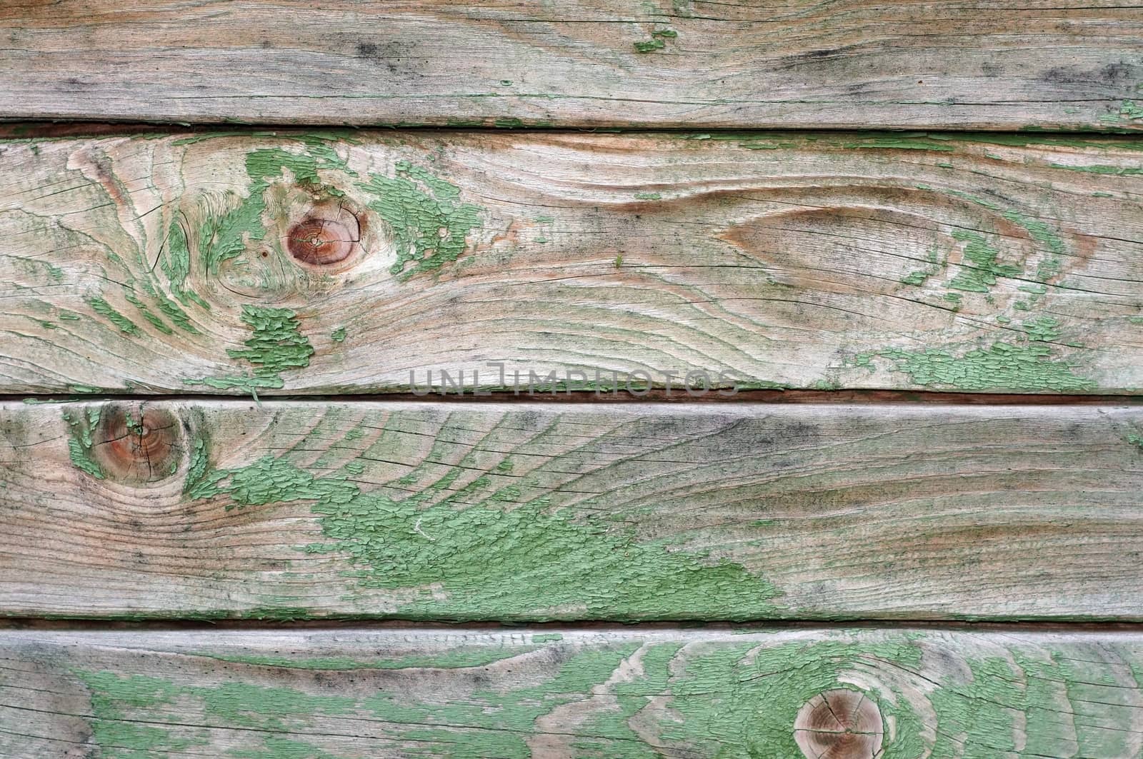 Texture of wall made of planks with paint peeling off close-up