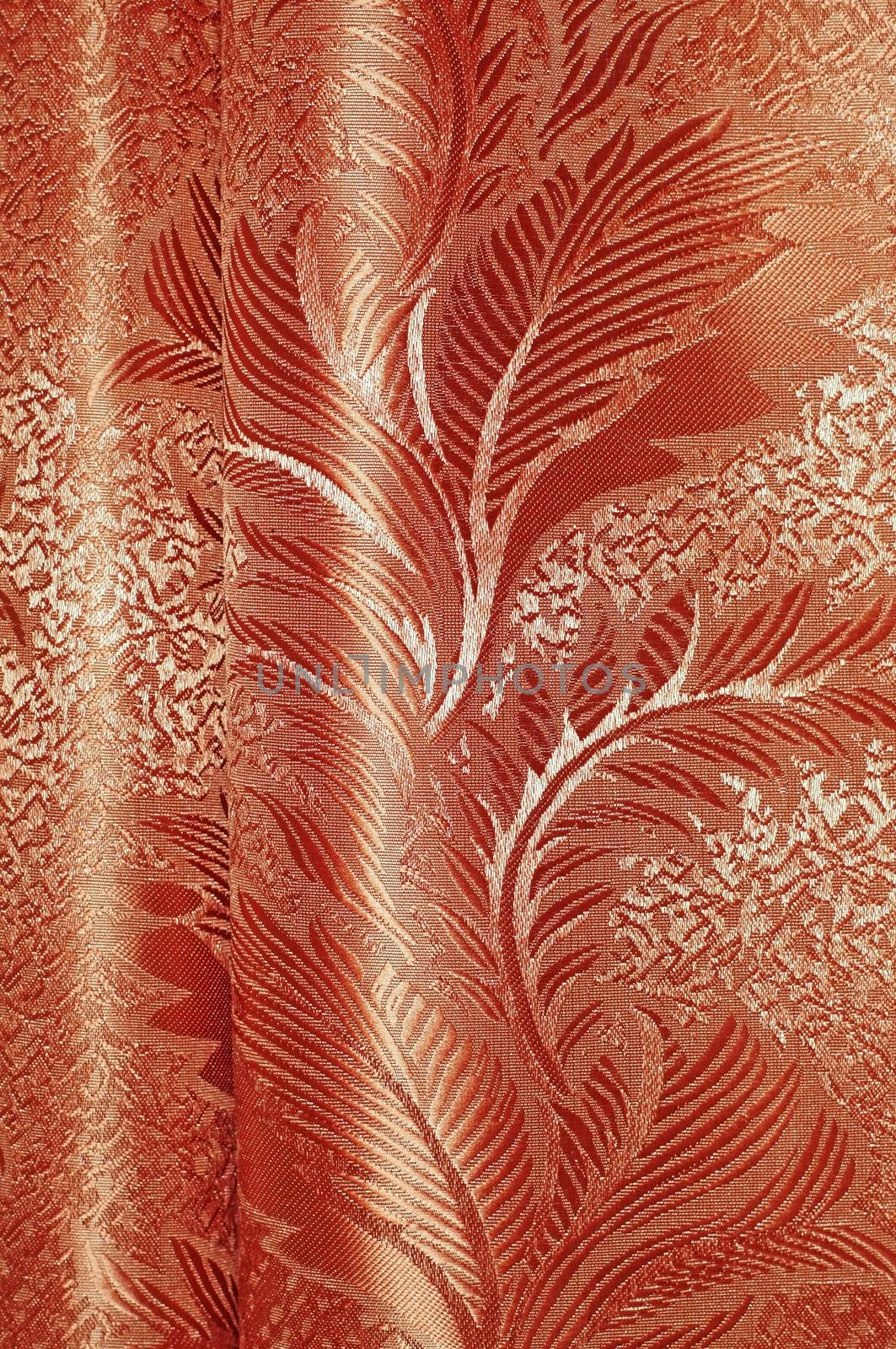 Texture of red and beige satin patterned curtains with folds