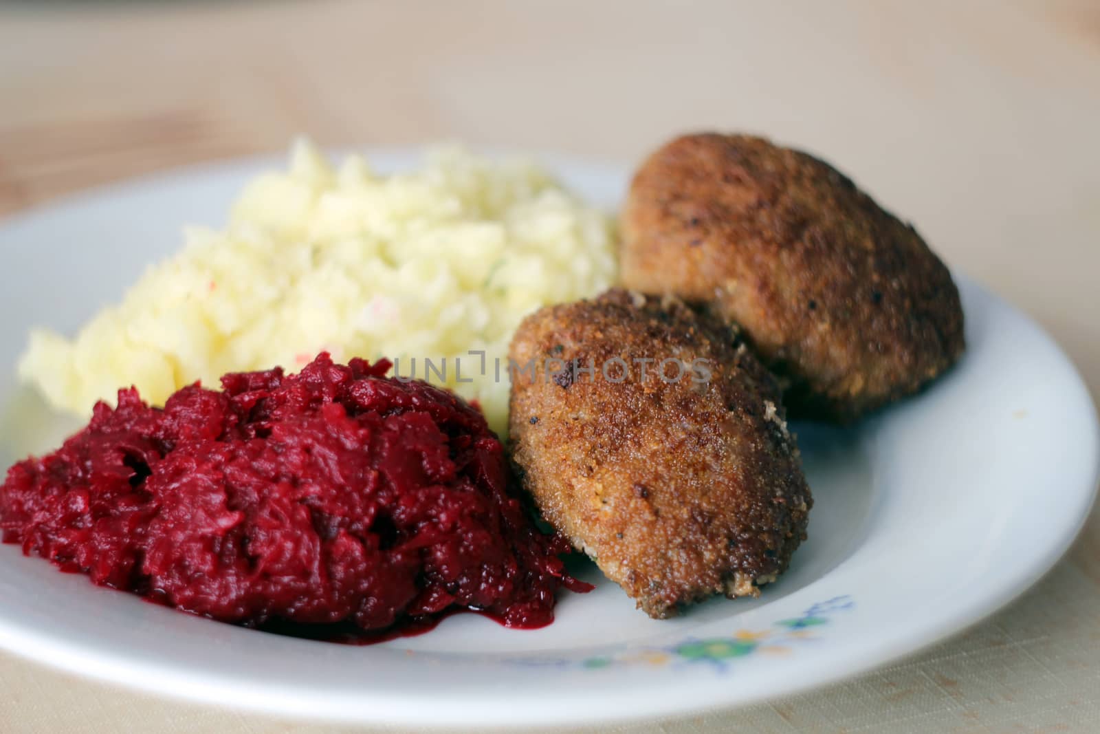 Pork chops with beetroot and potatoes on a white plate by sanzios