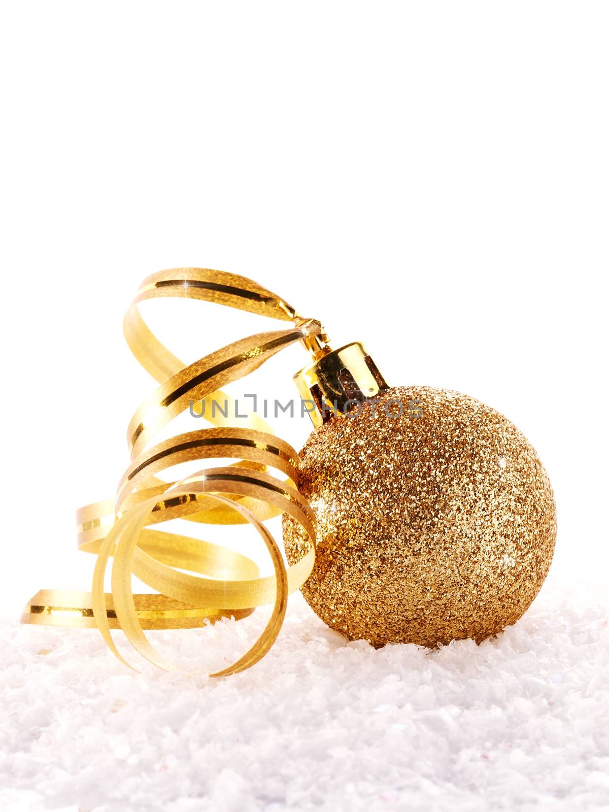 New Year's golden ball on snow with a tape. New Year's golden balls. Christmas balls. Christmas tree decorations. Christmas jewelry.