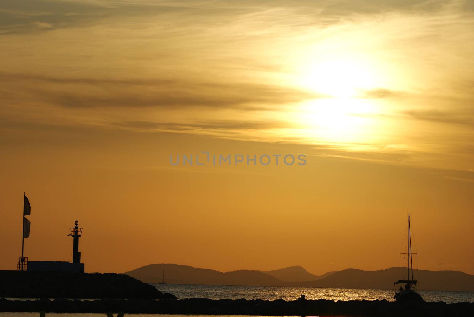 Photo is showing sunset above the beach and sea of Mallorca, Spain.