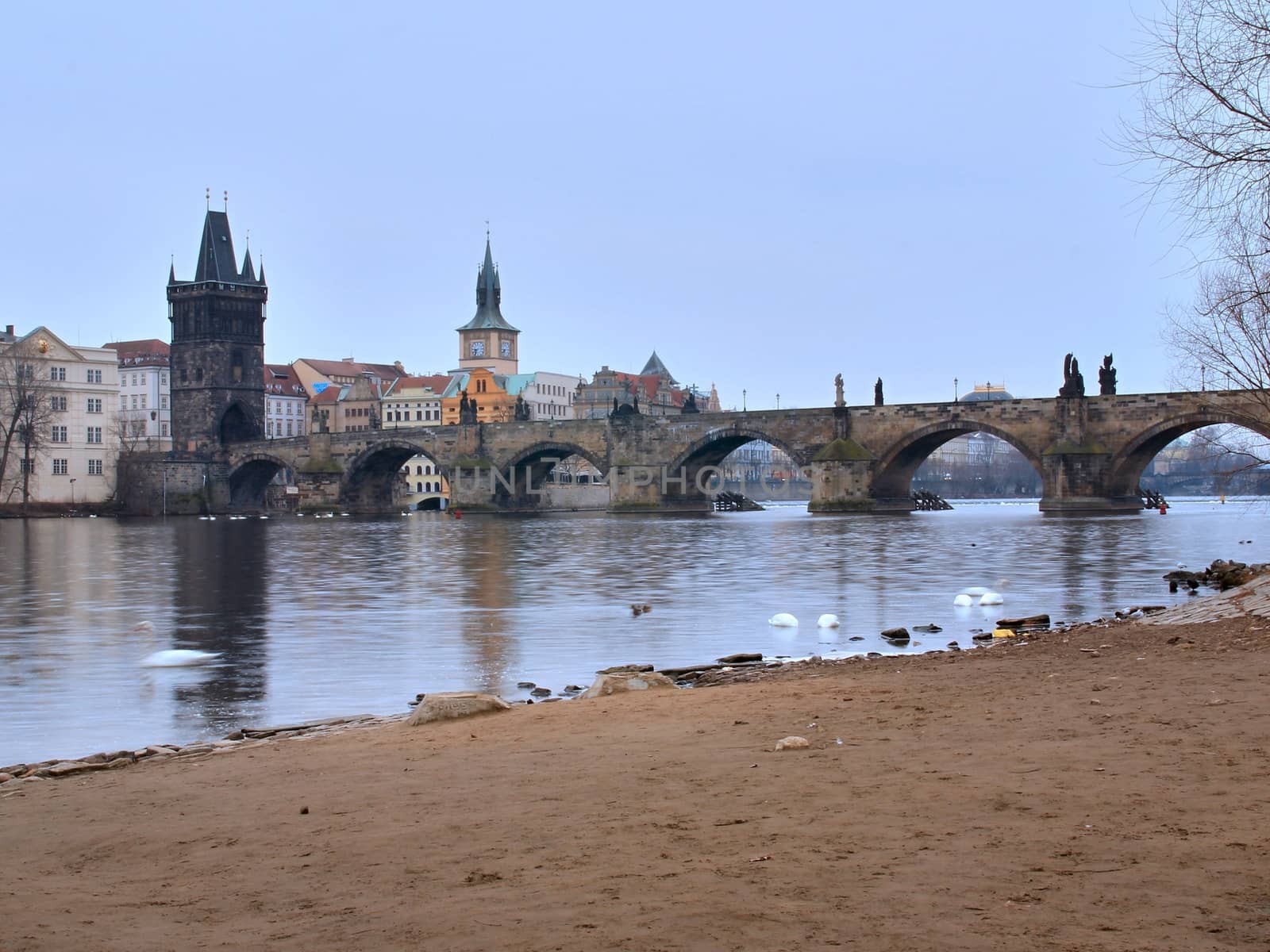 Photo of Charles bridge in Prague, Czech republic with the view onto old houses, towers and Vltava river.