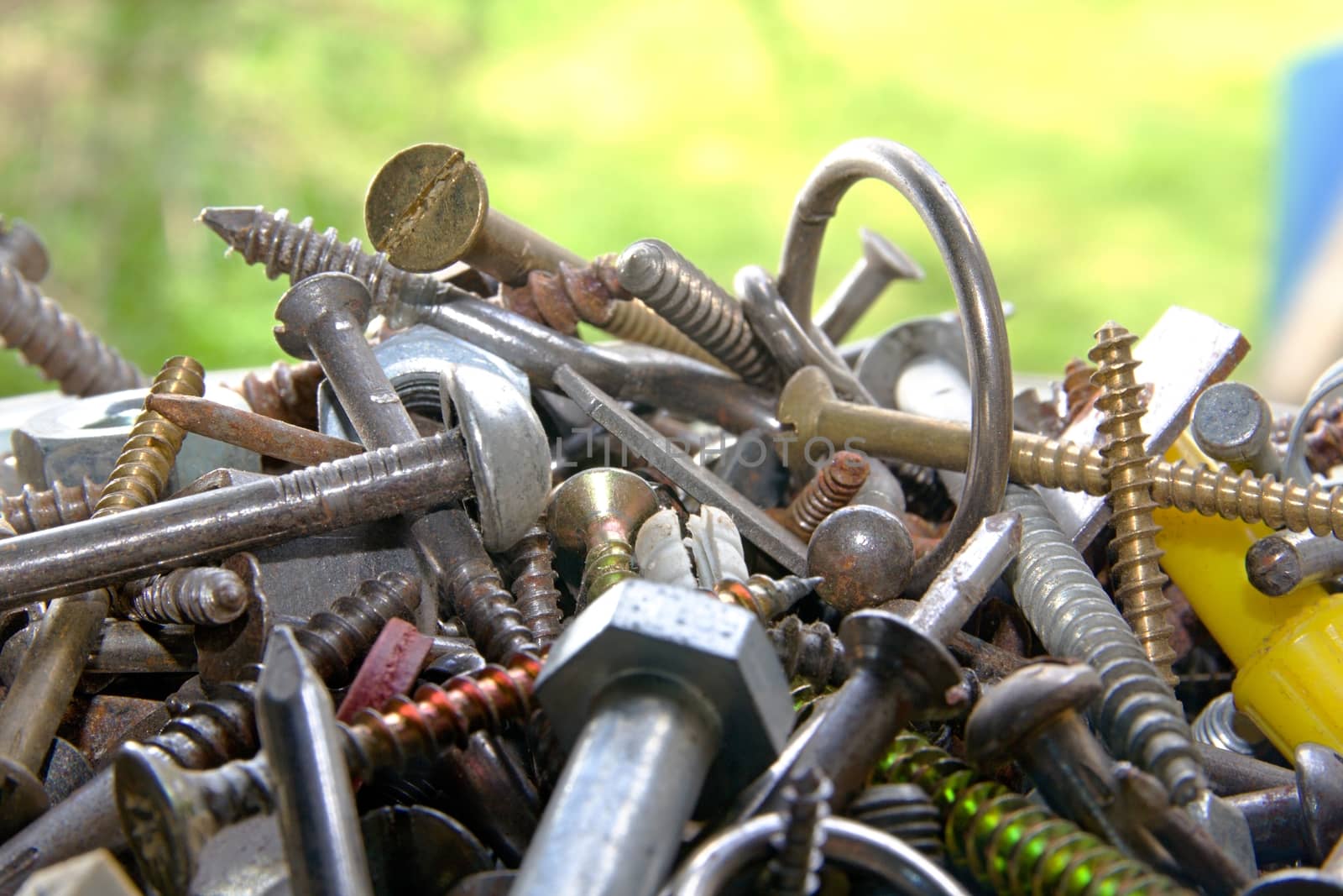 Photo shows mixture of various screws with green background.