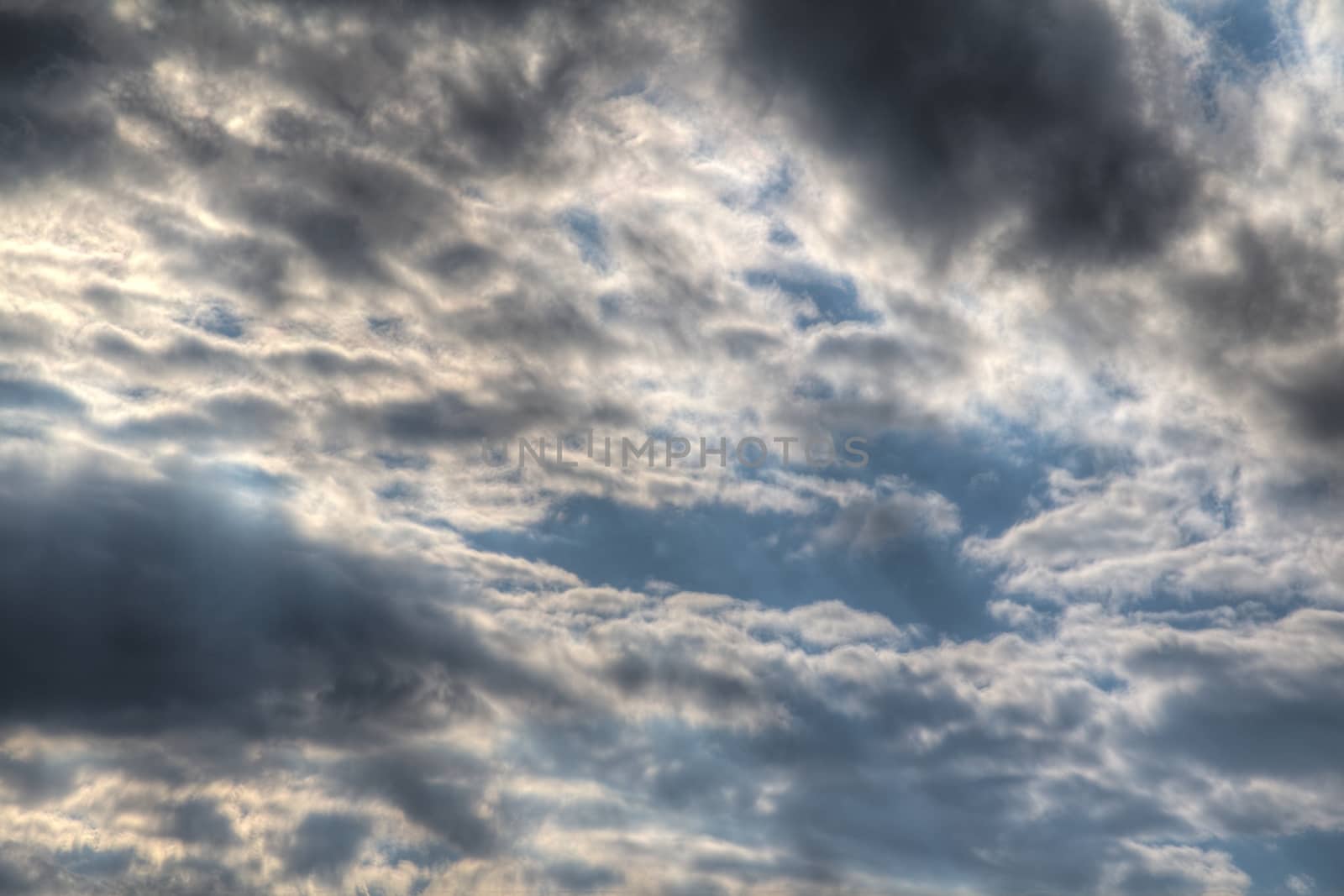 Photo shows general view of clouds with blue sky.