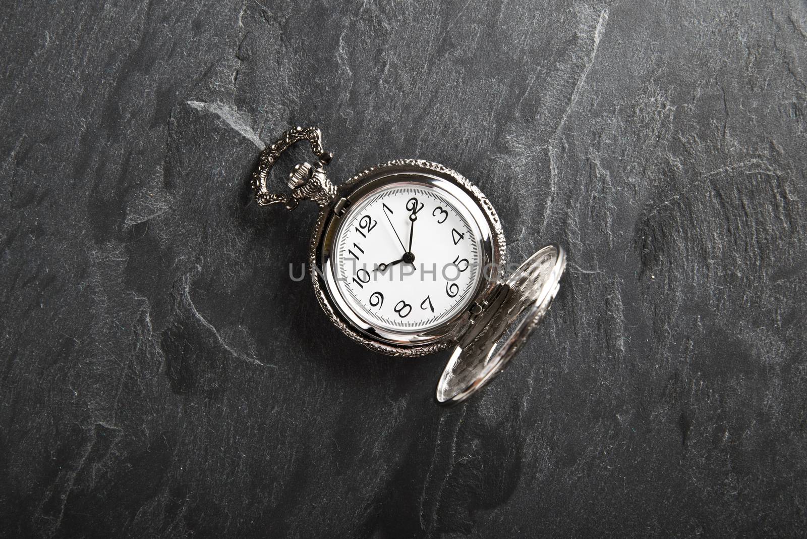 Pocket gray clock on dark gray slate texture