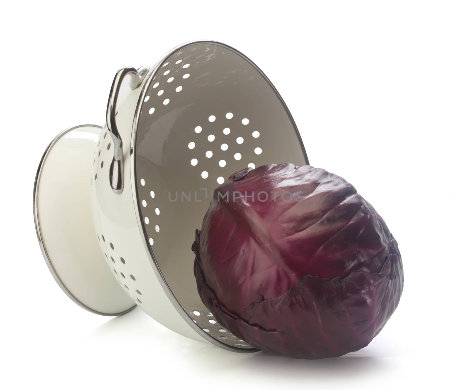 Red cabbage in the white enamel collander on the white background