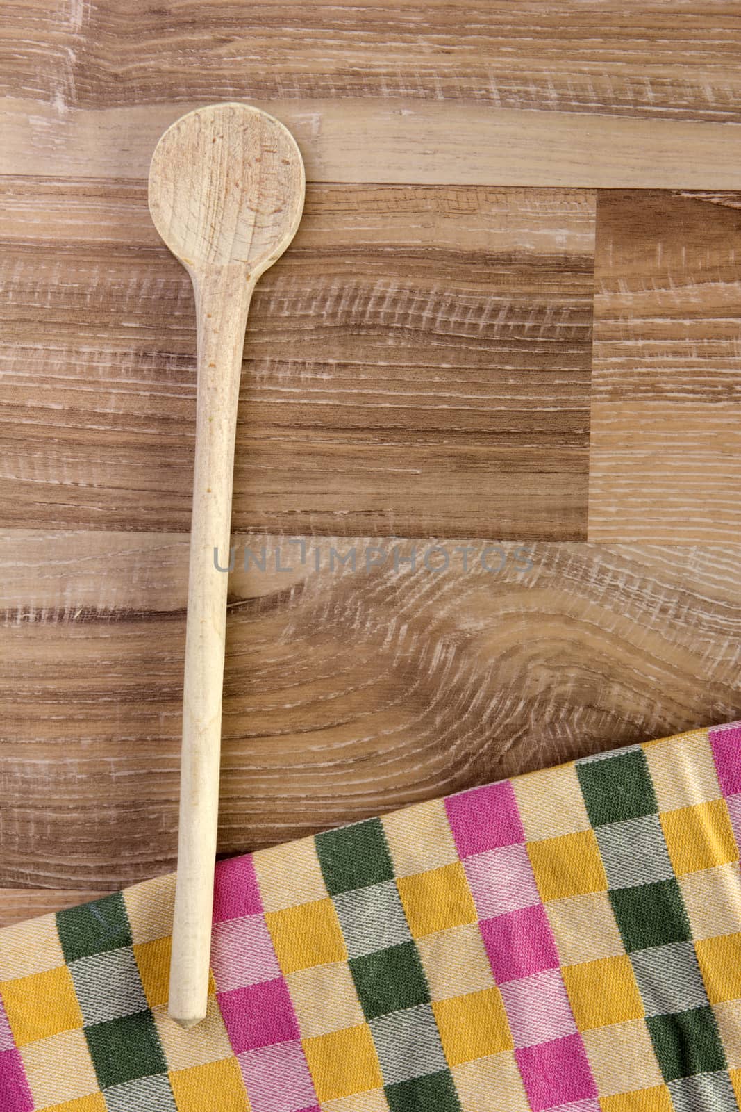 Wooden spoon on wood with colorful tea towel on wooden background 